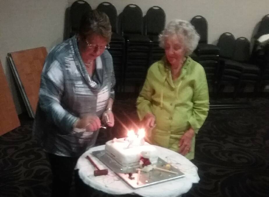 Leona Druett (president) and Brenda Cummings (only surviving founding member) cutting the 25th anniversary cake at the Empire Hotel on Friday night.